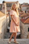 Рокля Сия в прасковено розово – цял силует на фона на кула в стария град